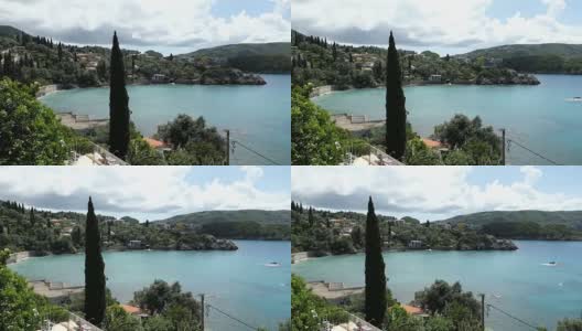 科孚岛(希腊)古奥卡斯特里萨镇海湾的鸟瞰图。森林，房屋和海岸线。船在泻湖附近行驶。高清在线视频素材下载