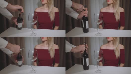 waiter opens a bottle of red wine for a woman in a restaurant高清在线视频素材下载