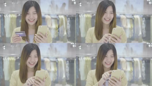 亚洲女性使用信用卡和手机进行网上购物的场景在百货商店的服装店无现金，技术钱钱包和在线支付概念，信用卡模型高清在线视频素材下载