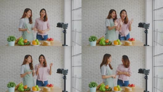 两名年轻的亚洲女性美食博主竖起大拇指，并在录制视频广播，视频博客健康的生活方式高清在线视频素材下载