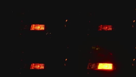 特写闪烁的黄色尾灯在晚上的汽车。缓慢的运动。高清在线视频素材下载