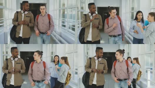 白人嬉皮士和非裔美国学生走在大学宽敞的玻璃走廊里讨论着什么，向女同学挥手，然后继续前进高清在线视频素材下载