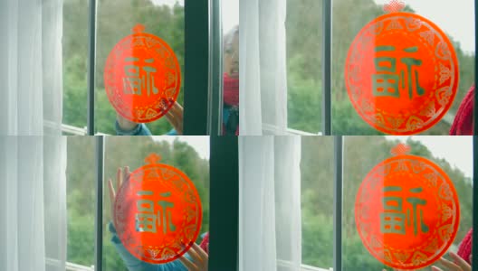 妇女把中国传统剪纸贴在窗户上高清在线视频素材下载