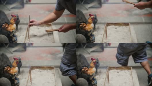 男子有条不紊地在亚洲鸡坛上烧香高清在线视频素材下载