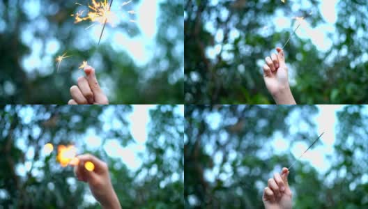 SLO MO女孩手握火花与自然树的背景高清在线视频素材下载