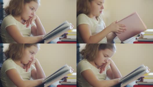 女孩不想学习功课，她很无聊，她推着一堆书，手里拿着一个手机。网络成瘾。他巧妙地微笑。使用手机高清在线视频素材下载