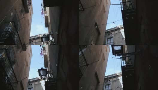 斯坦尼康镜头拍摄:在巴塞罗那的哥特式地区带阳台的房子。巴塞罗那狭窄街道上的老房子的正面。旅行的概念。慢动作高清在线视频素材下载