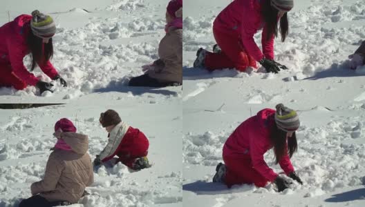 快乐的家庭在冬天的雪山森林里玩耍。妈妈和她的两个孩子扔雪球。做一个雪人。他们笑了。高清在线视频素材下载