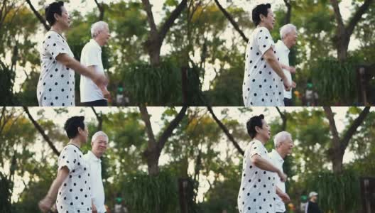 亚洲老年夫妇在公园里跳舞做有氧运动。一起欢笑，一起玩乐高清在线视频素材下载