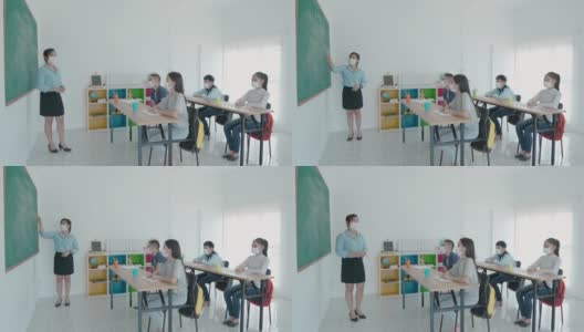 一群亚洲小学生和教师戴着卫生口罩在教室里防止Covid - 19的爆发，返校时重新开学，教育理念的新常态。高清在线视频素材下载