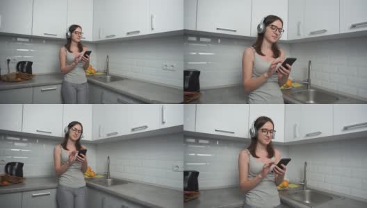 小女孩在厨房里用智能手机听音乐高清在线视频素材下载