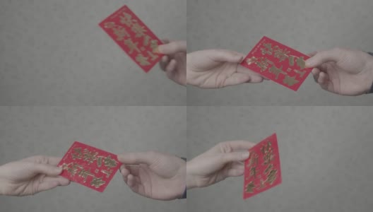近距离拍摄一只手从另一只手拿红口袋在中国新年高清在线视频素材下载