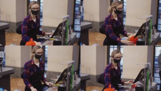 女收银员戴着防护口罩和手套用扫描仪刺穿产品高清在线视频素材下载