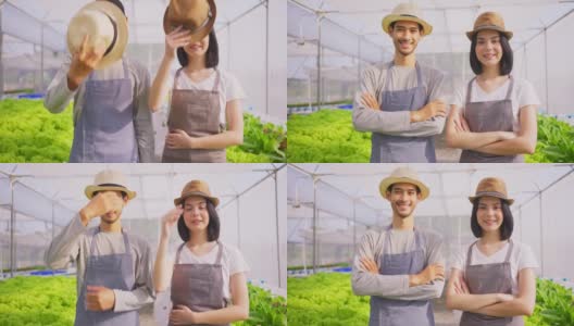两对亚洲夫妇农民在蔬菜水培农场工作幸福。男人和女人交叉手臂，看着镜头微笑，幸福和骄傲在温室农场。高清在线视频素材下载