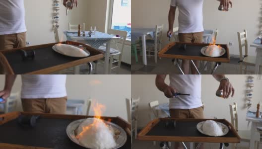 在希腊餐厅里，服务员用火焰技术向顾客展示盐烤鲈鱼高清在线视频素材下载