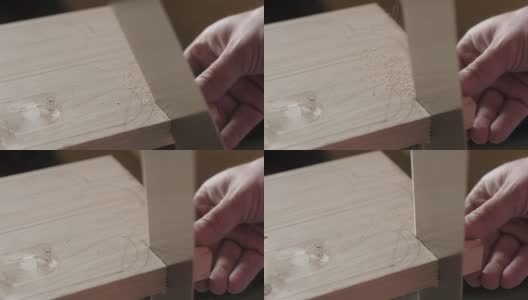 木匠用手锯从一块松木板上锯下一块木头。手工木工工具在工作。木工艺术高清在线视频素材下载