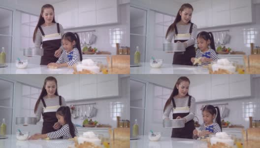 妈妈和孩子一起在家庭厨房做面团和烘焙，为家庭乐趣的概念。高清在线视频素材下载