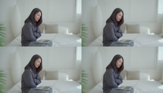 4k, Portrait，一个可爱的亚洲少女。穿着灰色衬衫，带着笔记本电脑在卧室的床上学习，一脸沉思高清在线视频素材下载