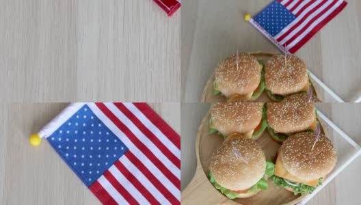 木制盘子里的四个汉堡，上面悬挂着两面美国国旗。高清在线视频素材下载