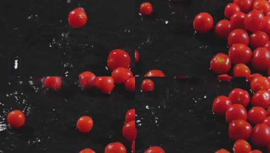 熟透的番茄落在潮湿的黑色桌子上，水花四溅。高清在线视频素材下载
