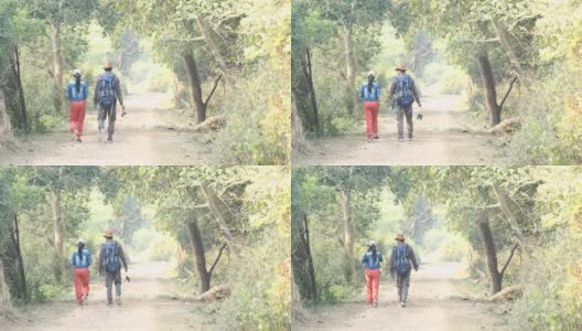 一对年轻夫妇在森林徒步旅行时用相机拍照高清在线视频素材下载