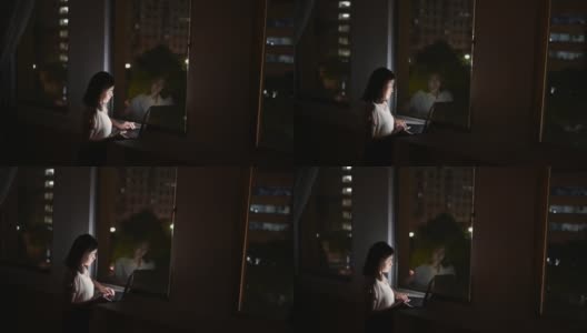 这张照片拍摄的是一位年轻的亚洲女商人，她在工作的深夜使用笔记本电脑。高清在线视频素材下载