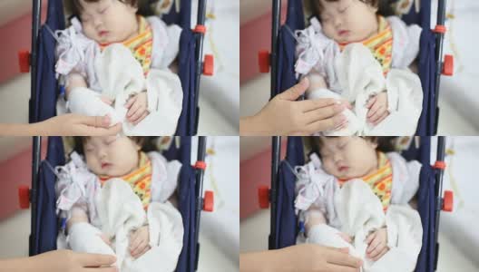 生病的婴儿在医院的安全座椅上接受生理盐水治疗高清在线视频素材下载