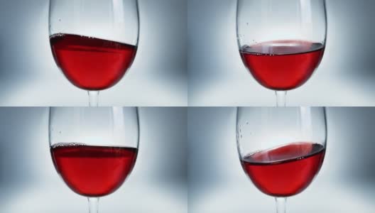 红酒在玻璃杯中像波浪一样从一边溅到另一边的创意宏慢动作视频。玻璃与溅起的葡萄酒近距离。高清在线视频素材下载