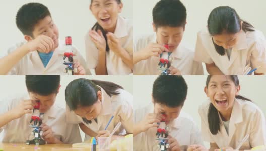 亚洲小学生穿着实验服一起在科学课上使用显微镜，教育理念。高清在线视频素材下载
