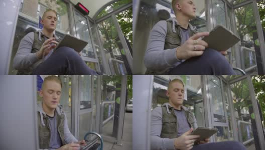男孩在公交车站用平板电脑高清在线视频素材下载