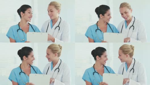 两个医生一边看着写字板一边交谈着高清在线视频素材下载