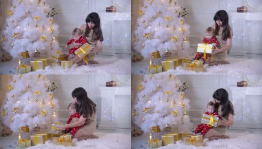 小婴儿和妈妈在圣诞树旁玩耍。新年装饰和概念的第一步高清在线视频素材下载