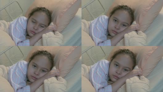 亚裔美国少女躺在病床上，推着娃娃高清在线视频素材下载