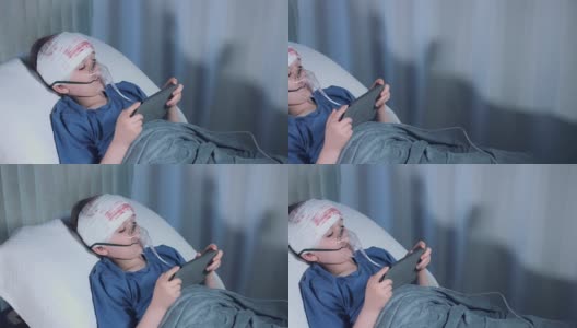 医院拍摄的4k受伤儿童戴着氧气面罩在平板电脑上玩游戏高清在线视频素材下载