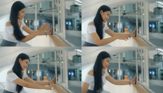 微笑的泰国女孩正在用智能手机自拍高清在线视频素材下载