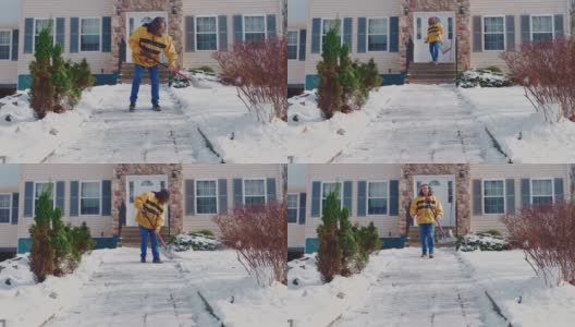 一名50岁的长头发男子，身穿黄色夹克，正在清理一场冬季降雪后乡间屋前院子里的积雪。科勒,宾夕法尼亚州,美国高清在线视频素材下载