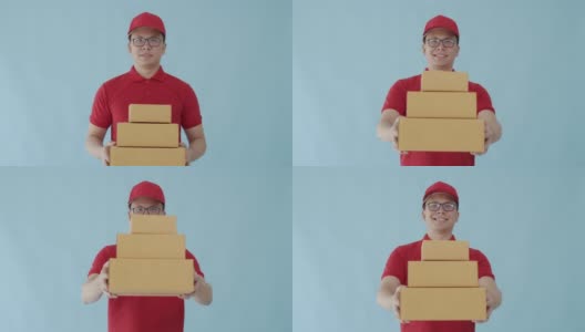 亚洲快乐快递员携带纸包盒子孤立在蓝色背景与微笑的脸。邮政投递服务的概念。高清在线视频素材下载
