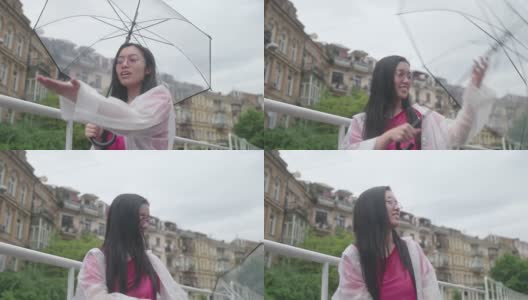 年轻的亚洲女人高兴雨停了，合上伞去散步高清在线视频素材下载