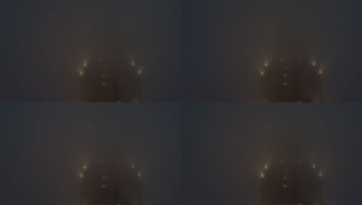 在浓雾中，一幢高层建筑上闪烁着亮光。高清在线视频素材下载