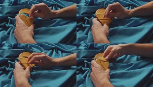 男人的手会掰出心形的糖饼干。高清在线视频素材下载