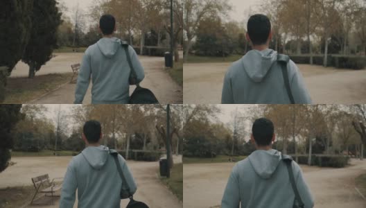 强壮的男人和运动员在去健身房的路上，背着运动背包穿过一个公园高清在线视频素材下载