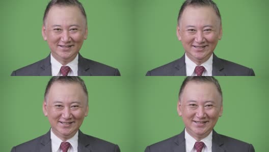 成熟快乐的日本商人在绿色背景下微笑高清在线视频素材下载
