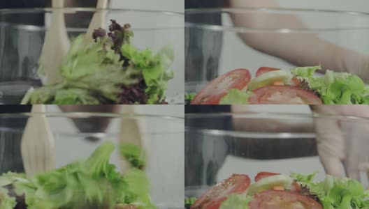 慢镜头——注重健康的年轻女酋长在搅拌美味的有机绿色沙拉。高清在线视频素材下载
