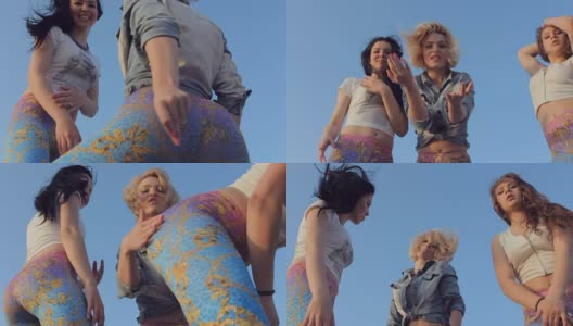 三个时髦的女孩穿着相似的明亮的紧身裤在街上跳舞高清在线视频素材下载