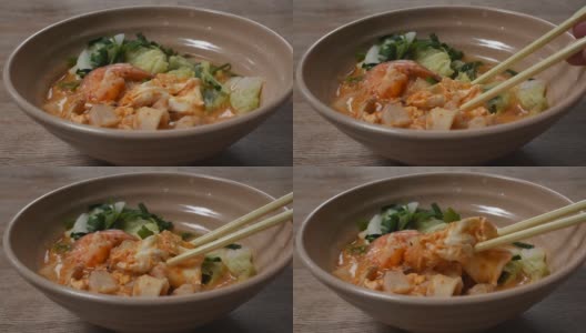 煮海鲜sukiyaki在汤与酱用筷子挑选高清在线视频素材下载