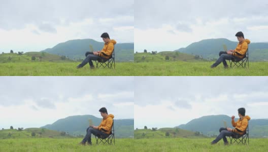 4K亚洲人坐在山上用笔记本电脑工作高清在线视频素材下载