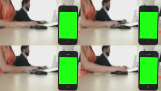 智能手机-绿色屏幕-男人和女人工作的电脑在办公室的背景高清在线视频素材下载