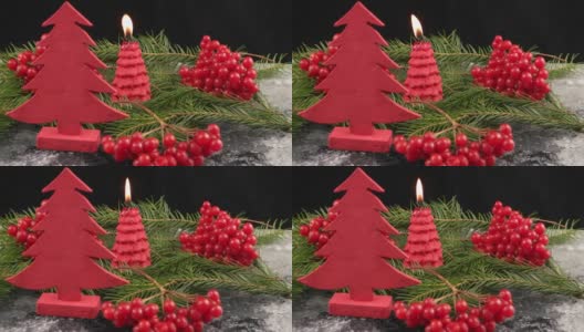 圣诞节的静物与红色的荚莲浆果，圣诞树，燃烧的蜡烛和雪在黑色的背景高清在线视频素材下载