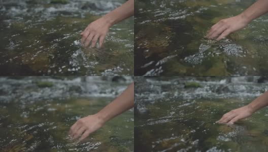 靠近女人的手触摸水面在森林河流或湖泊。高清在线视频素材下载