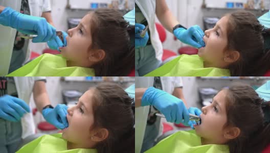 在一次拔牙时，勇敢的女孩坐在牙医的椅子上竖起大拇指高清在线视频素材下载